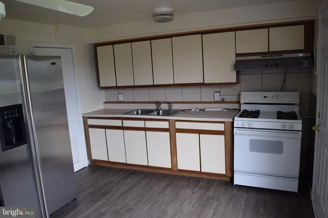 a kitchen with a refrigerator sink and cabinets