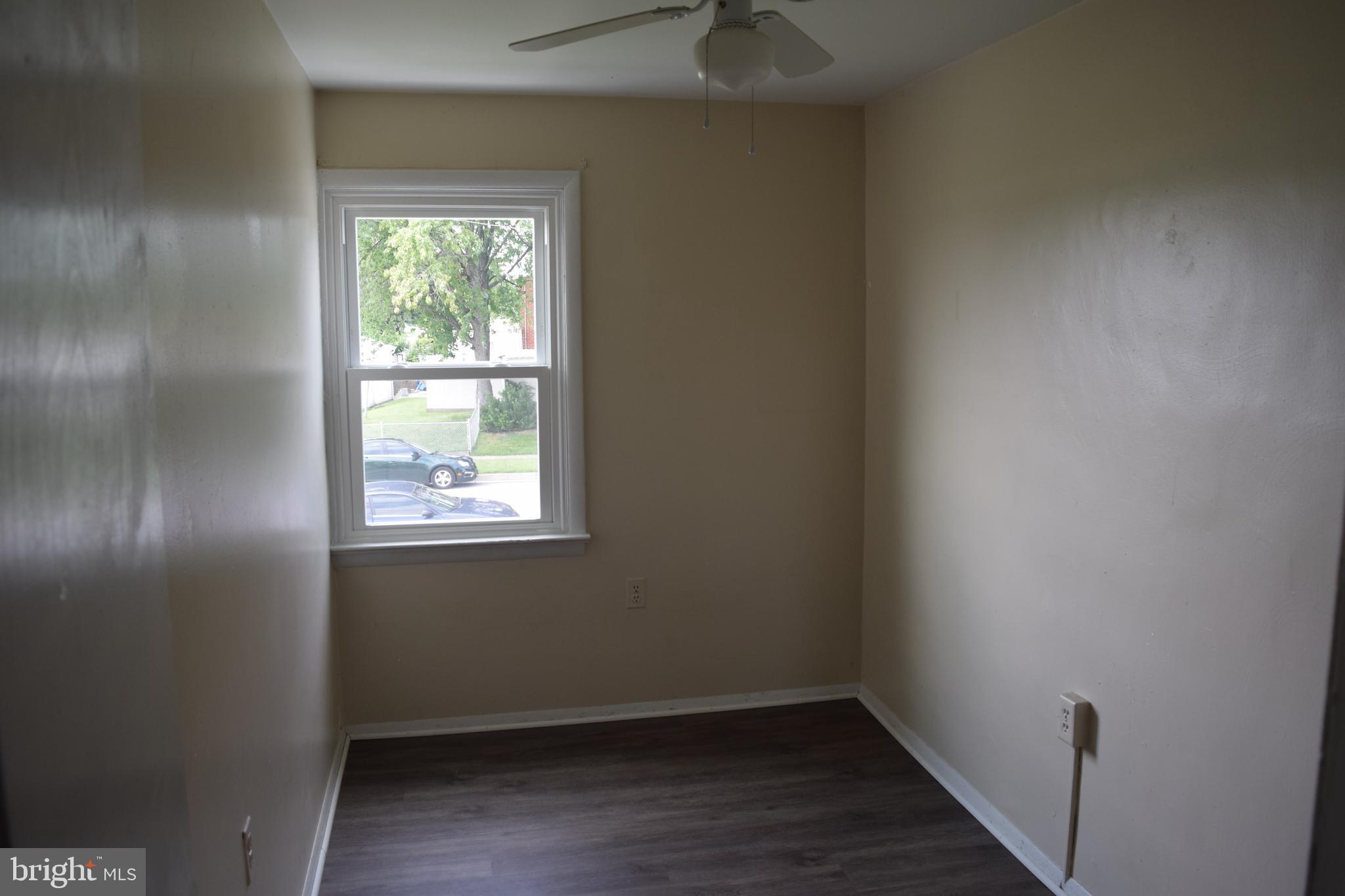 2111 Larkhall Road Baltimore, MD 21222 - Photo 9 of 13 an empty room with wooden floor and windows