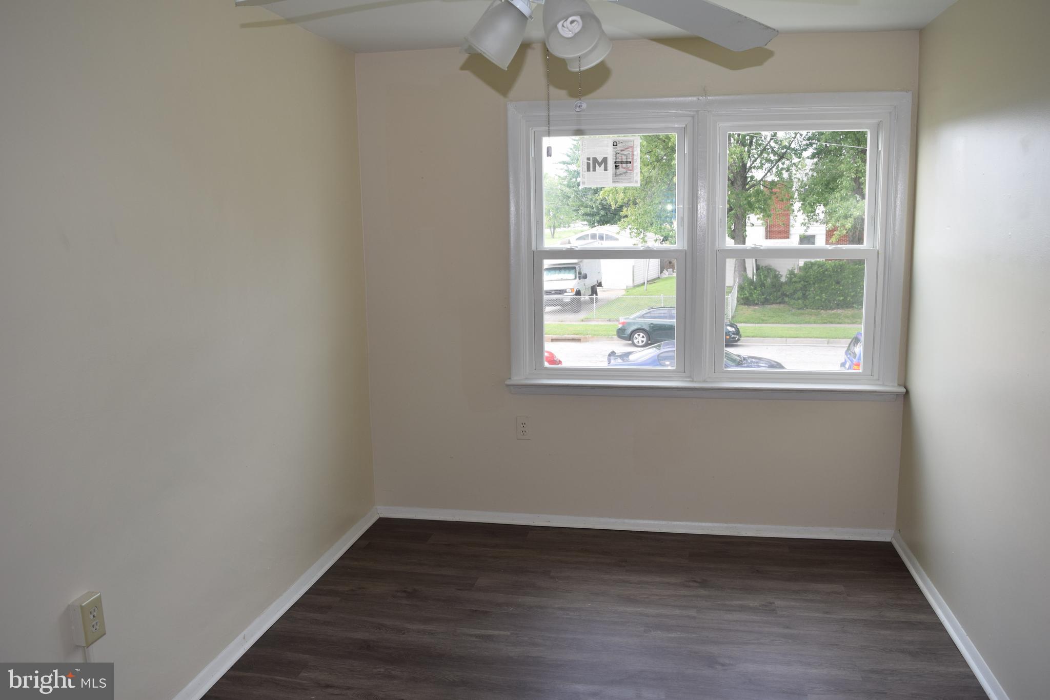 2111 Larkhall Road Baltimore, MD 21222 - Photo 10 of 13 an empty room with wooden floor and windows