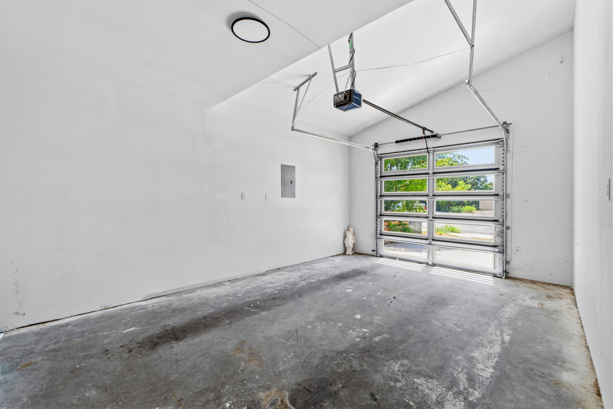 5010 Baker Street Austin, TX 78721 - Photo 20 of 22 Concrete flooring and high ceilings define this versatile garage with a glass-paneled roll-up door.