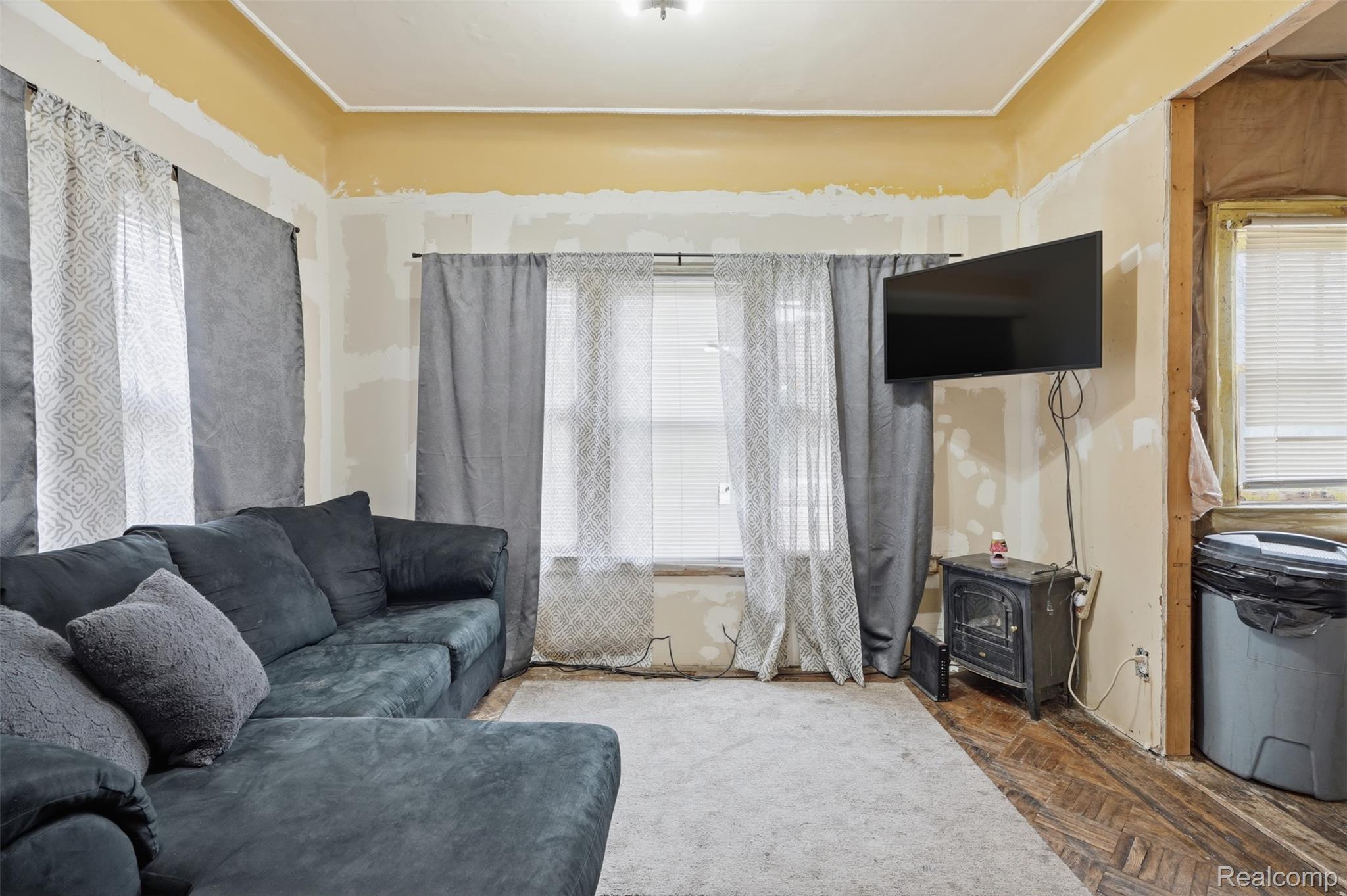 2500 Atkinson Street Detroit, MI 48206 - Photo 6 of 21 Living room featuring a wood stove, plenty of natural light, and parquet floors