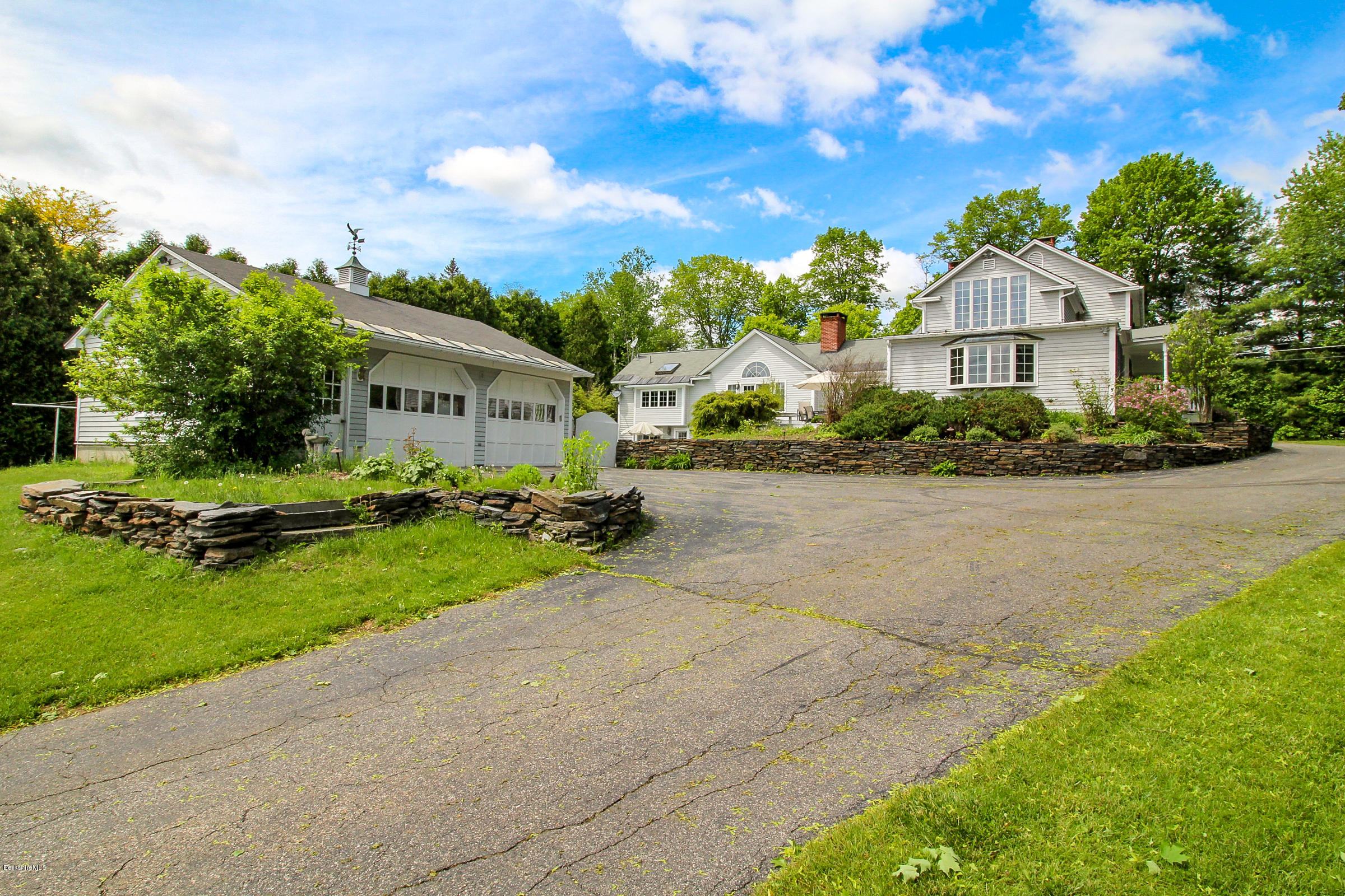 215 Devon Road Lee, MA 01238 - Photo 4 of 59 a front view of a house with a garden and trees