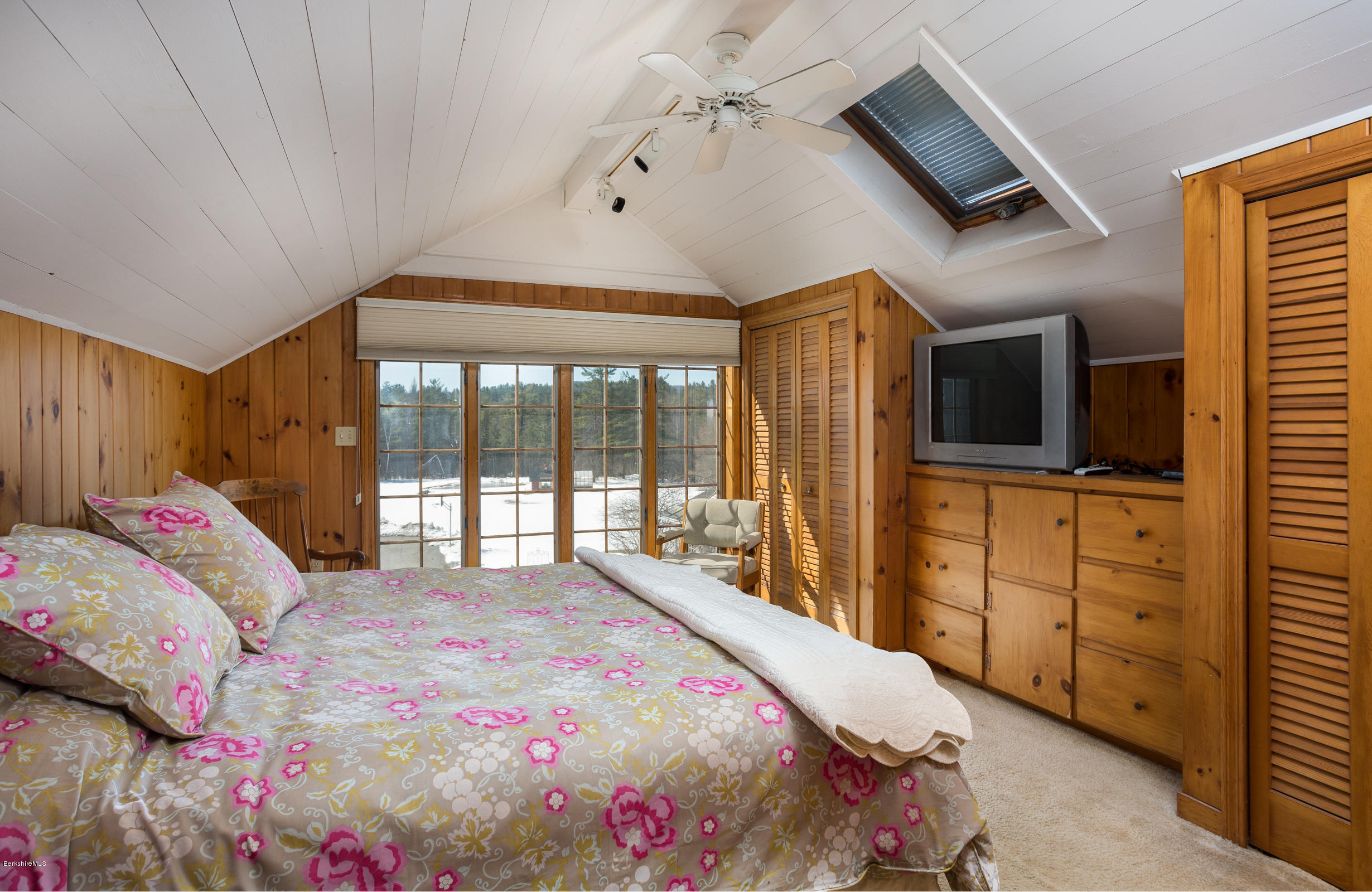 215 Devon Road Lee, MA 01238 - Photo 31 of 59 a bedroom with a large bed and a flat tv screen on dresser