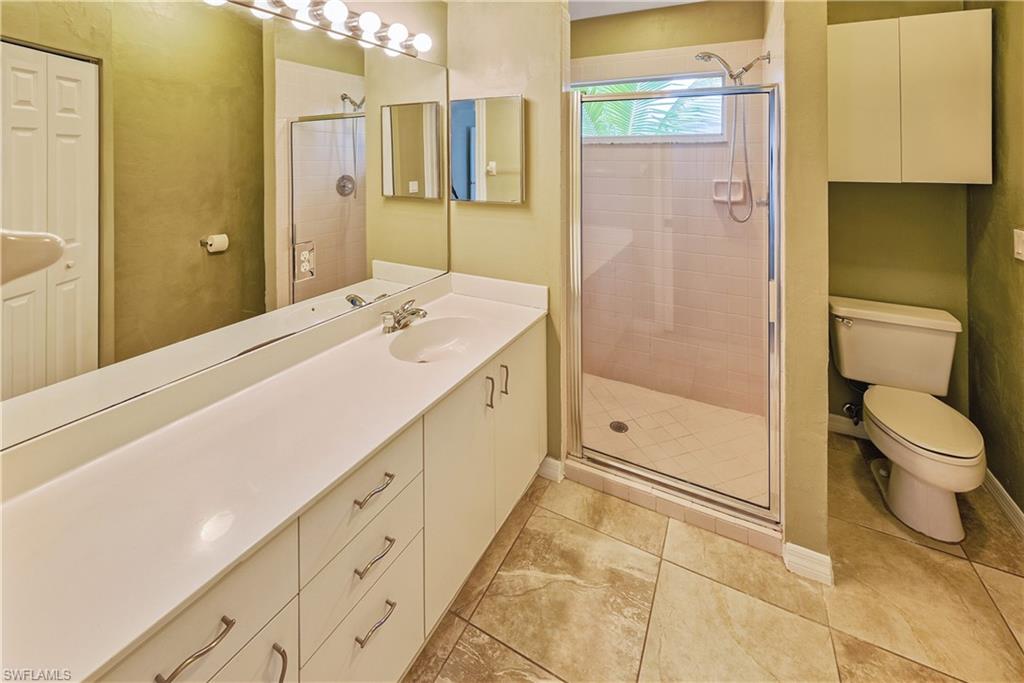6721 Sloane Place Naples, FL 34104 - Photo 13 of 29 a spacious bathroom with a shower sink and mirror