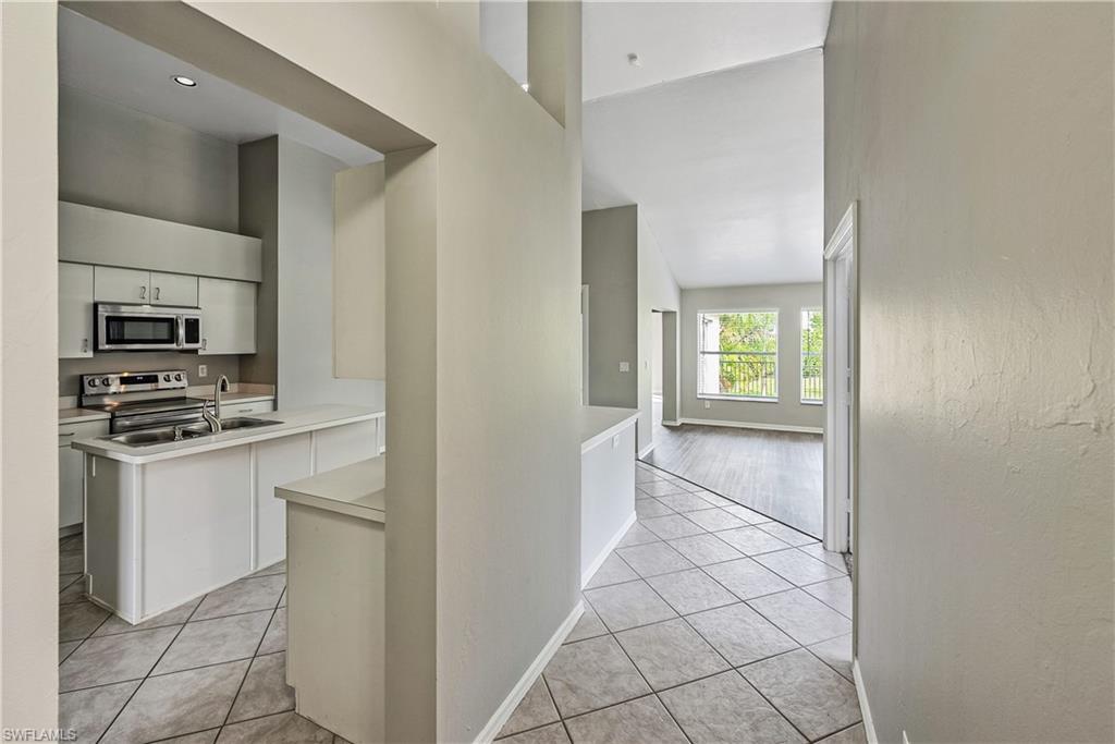 6721 Sloane Place Naples, FL 34104 - Photo 4 of 29 a kitchen with white cabinets and appliances