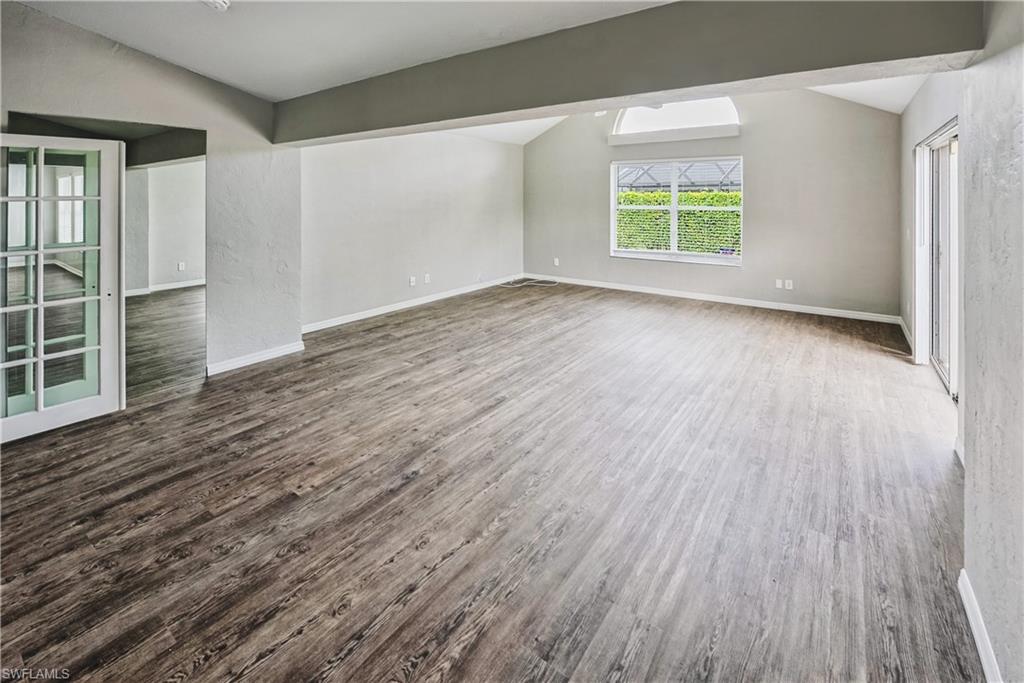 6721 Sloane Place Naples, FL 34104 - Photo 5 of 29 an empty room with wooden floor and windows