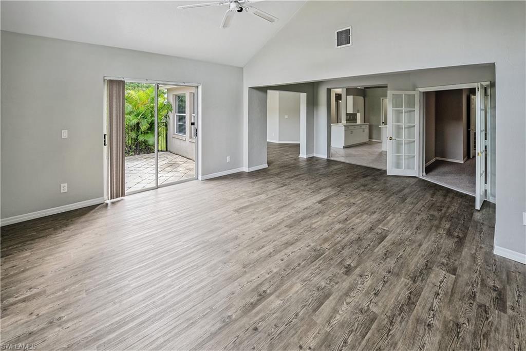6721 Sloane Place Naples, FL 34104 - Photo 6 of 29 an empty room with wooden floor and windows