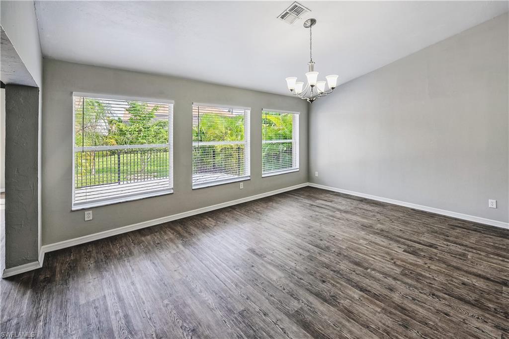 6721 Sloane Place Naples, FL 34104 - Photo 7 of 29 an empty room with wooden floor and windows