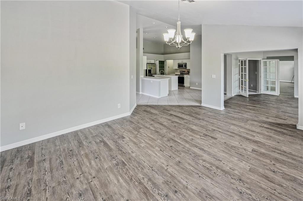 6721 Sloane Place Naples, FL 34104 - Photo 8 of 29 a view of a livingroom with wooden floor and a kitchen space