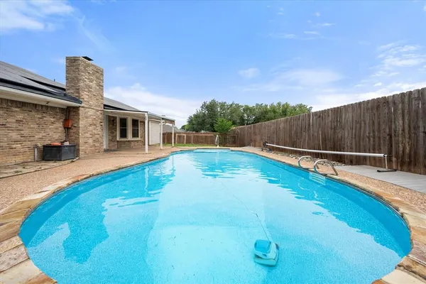 a view of a swimming pool with a patio and a yard