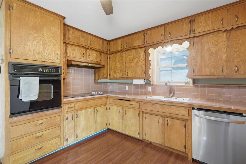 4105 Springbranch Drive Benbrook, TX 76116 - Photo 12 of 27 a kitchen with stainless steel appliances granite countertop a sink and cabinets with wooden floor