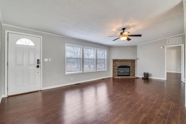 an empty room with windows and a fireplace