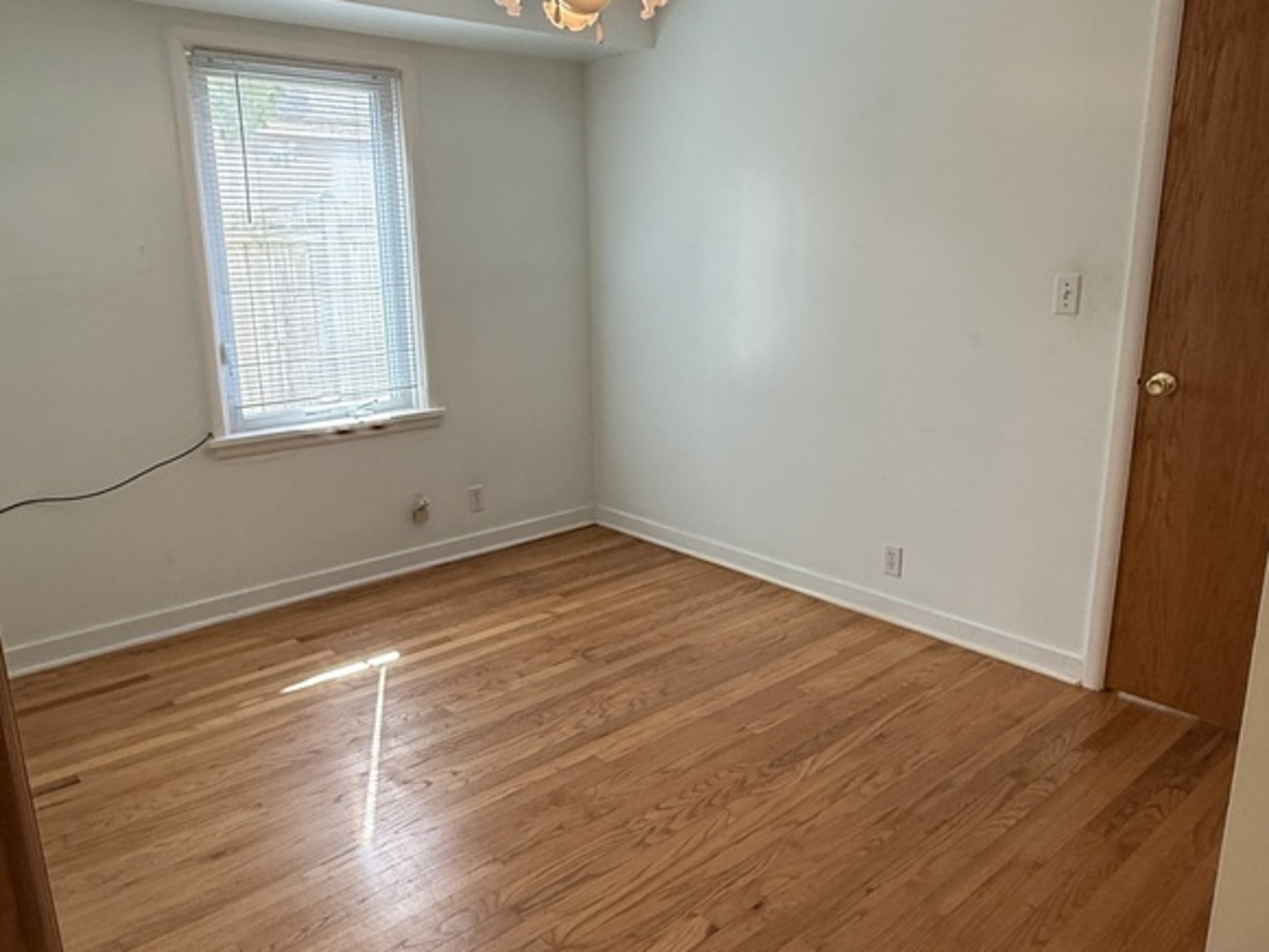 125 Maple Court, Unit 1 Geneva, IL 60134 - Photo 14 of 18 an empty room with wooden floor and windows