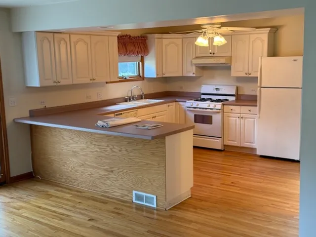 a kitchen with stainless steel appliances granite countertop a stove a sink and a refrigerator