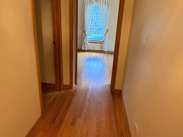 a view of a hallway with wooden floor