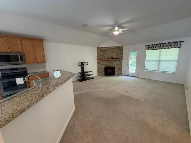 a open kitchen with granite countertop a sink dishwasher stove and cabinets