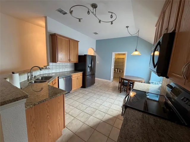 a kitchen with a sink appliances and cabinets