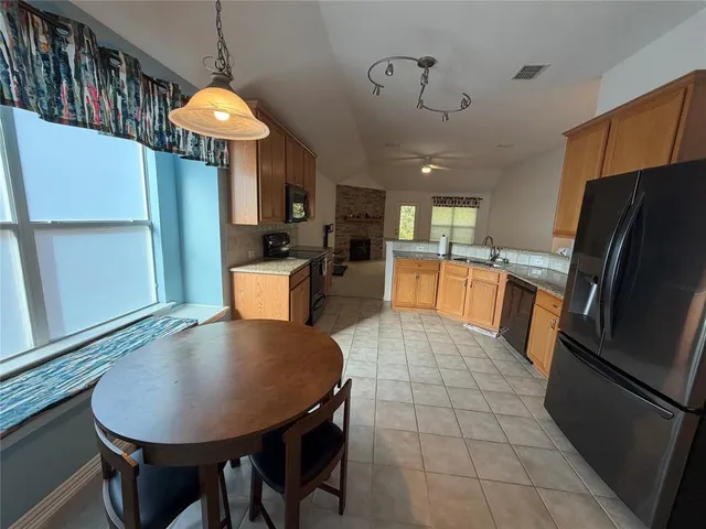 a kitchen with stainless steel appliances granite countertop a sink refrigerator and microwave