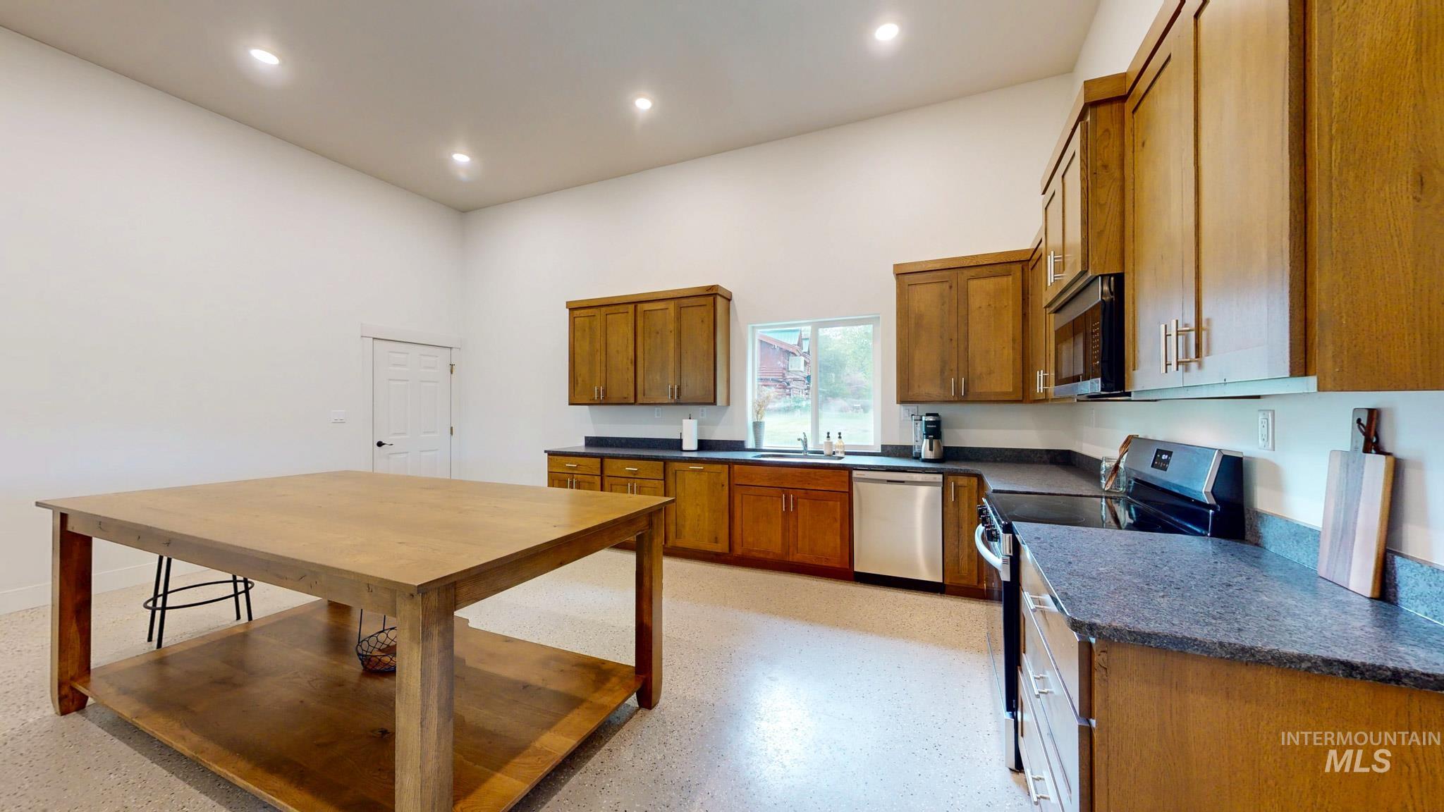 863 Pottery Road Bliss, ID 83314 - Photo 18 of 45 Kitchen featuring vaulted ceilings, recessed lighting, wood-finish cabinetry, dark countertops, and stainless steel appliances