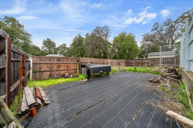 a view of a backyard with wooden fence