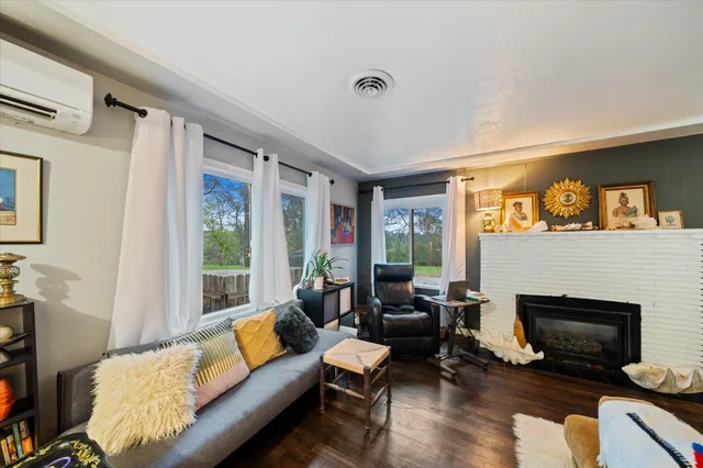 a living room with furniture a large window and a fireplace