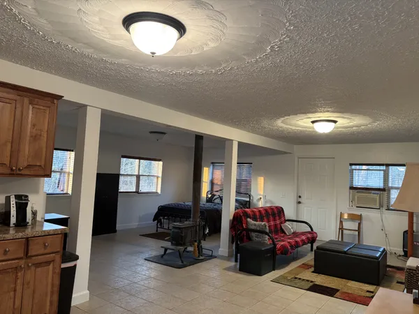 a living room with furniture and a refrigerator