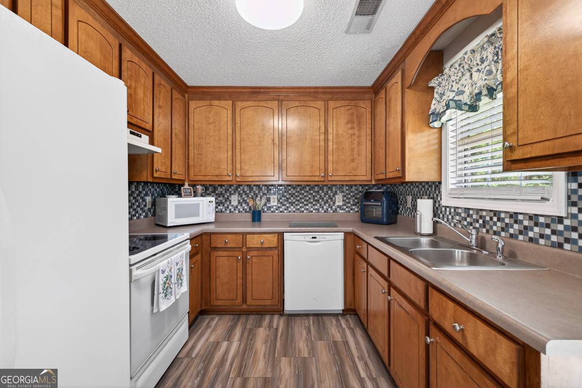 141 Pope Street Zebulon, GA 30295 - Photo 12 of 42 a kitchen with stainless steel appliances granite countertop a sink and cabinets