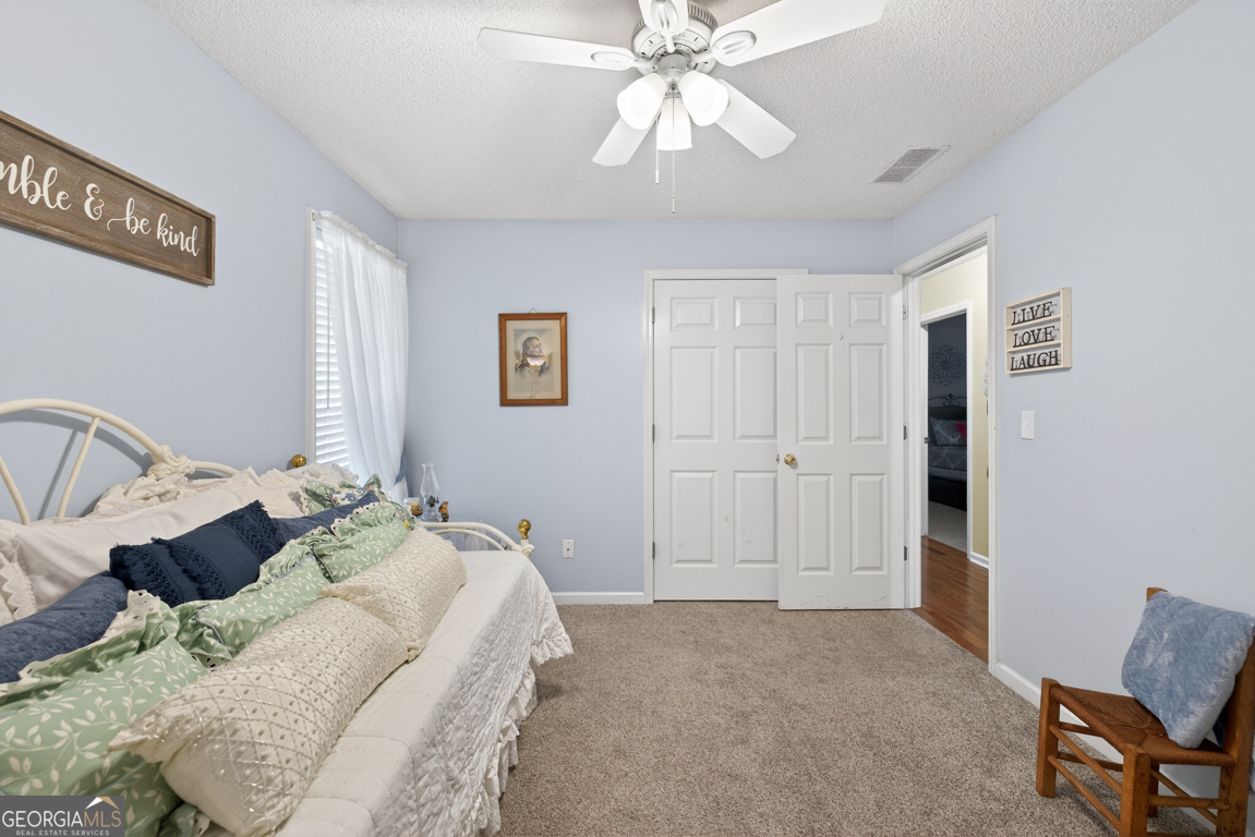 141 Pope Street Zebulon, GA 30295 - Photo 17 of 42 a spacious bedroom with a bed and a chandelier