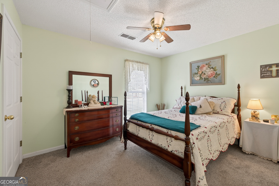 141 Pope Street Zebulon, GA 30295 - Photo 20 of 42 a bedroom with a bed and a chandelier
