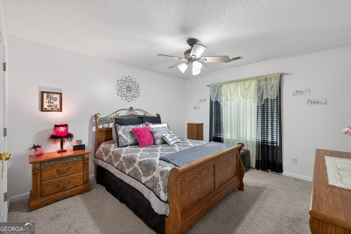 141 Pope Street Zebulon, GA 30295 - Photo 24 of 42 a bedroom with a bed and a chandelier