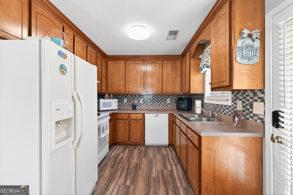 141 Pope Street Zebulon, GA 30295 - Photo 10 of 42 a kitchen with stainless steel appliances granite countertop a refrigerator a sink and dishwasher a stove with wooden floor
