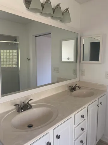 a bathroom with a sink and two mirror