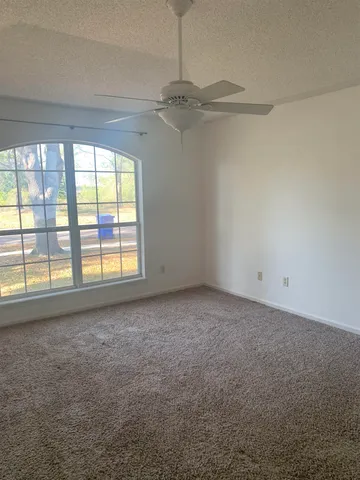 en empty room with windows and chandelier