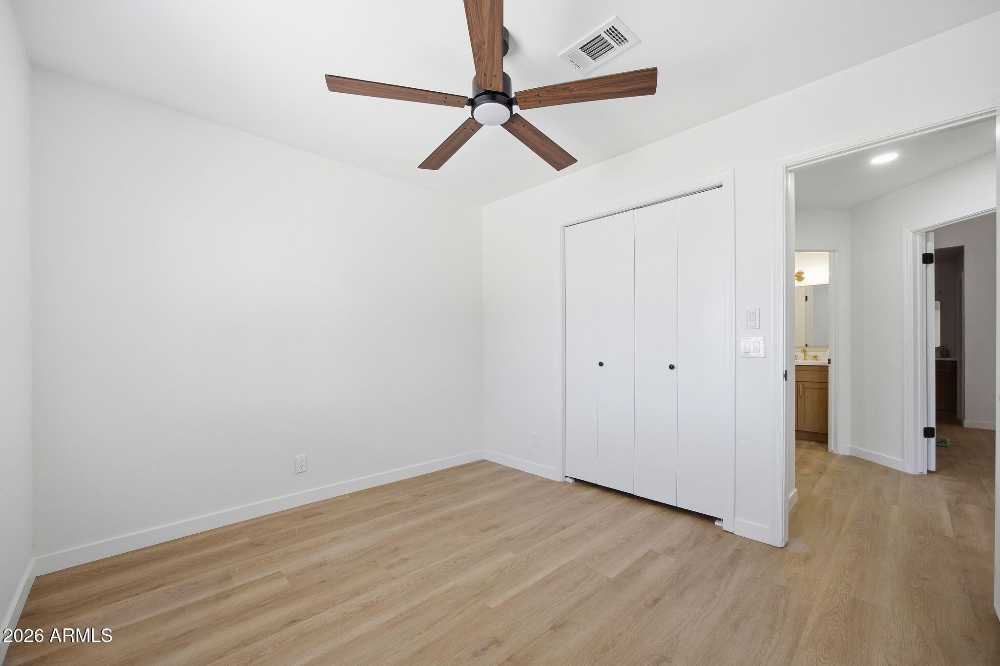 3134 East McKellips Road, Unit 69 Mesa, AZ 85213 - Photo 20 of 24 a view of a room with wooden floor and a ceiling fan