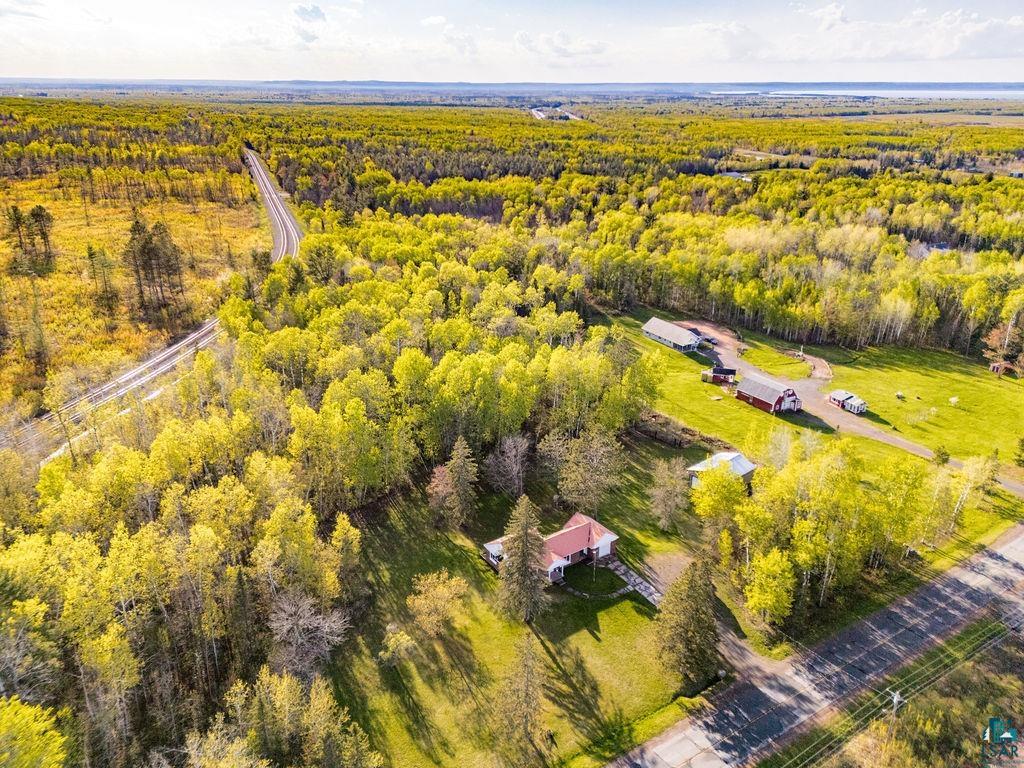 4543 County Road East South Range, WI 54874 - Photo 38 of 43 Expansive aerial property featuring a single-family home with a red roof, surrounded by mature trees and lush green lawns