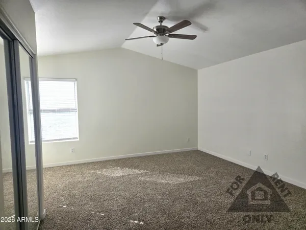 an empty room with a window and a ceiling fan