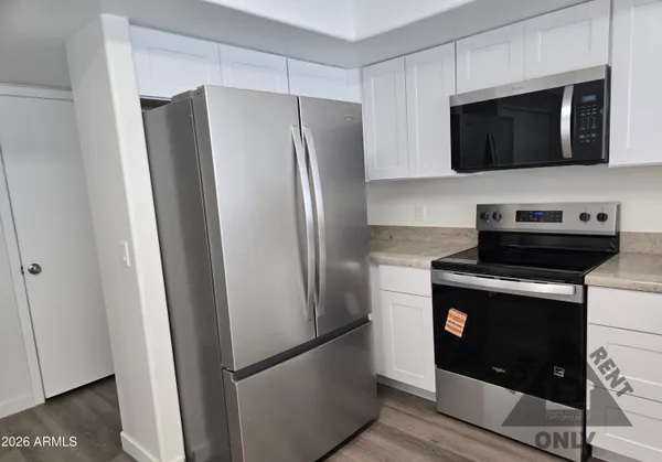 a metallic refrigerator freezer sitting in a kitchen