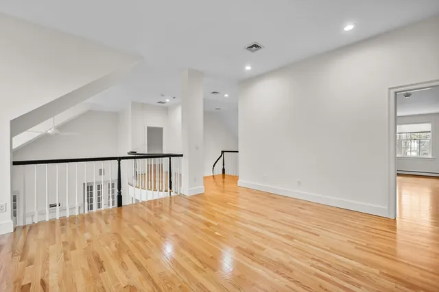 a view of empty room with wooden floor and windows