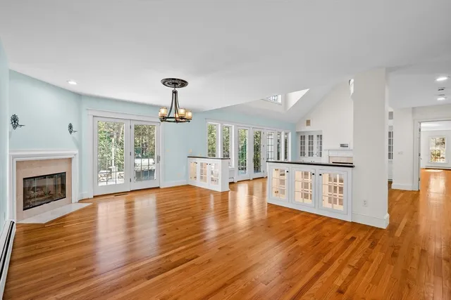 a view of empty room with wooden floor and fireplace
