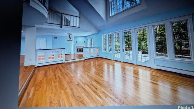 a view of a living room with stainless steel appliances wooden floor and a large window
