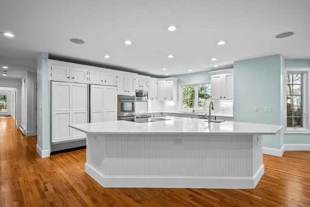 a large kitchen with granite countertop a large counter top stainless steel appliances and cabinets