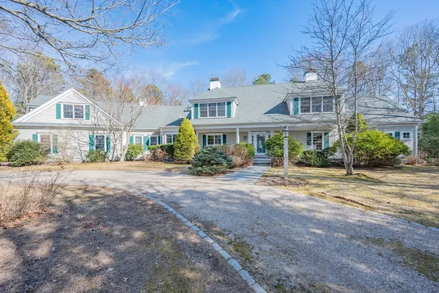 a front view of a building with a garden and plants