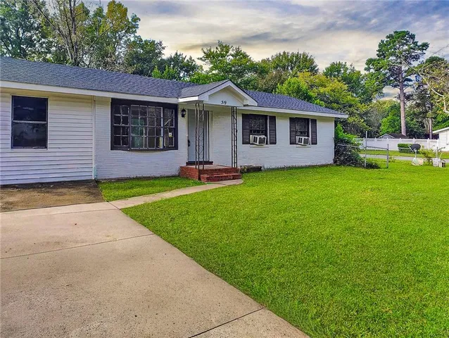 a front view of a house with a garden and yard
