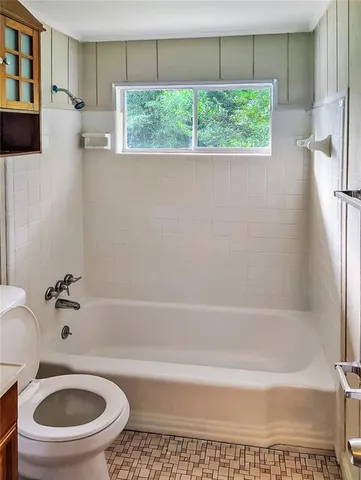 a bath room with a toilet and a bath tub