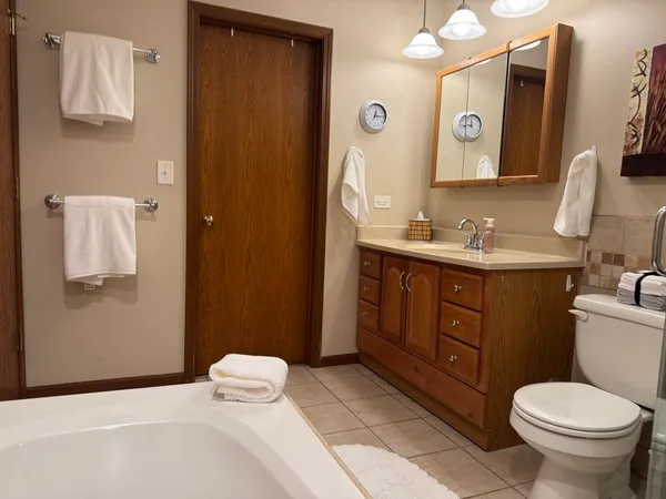 a bathroom with a toilet sink vanity and mirror