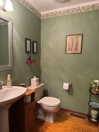 a bathroom with a toilet a sink and mirror