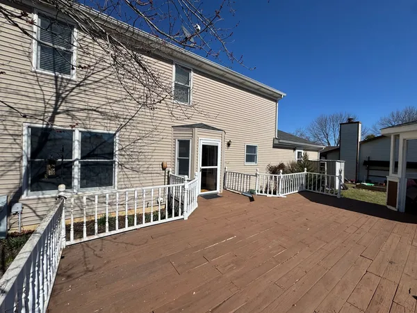 a view of a house with barbeque and wooden fence