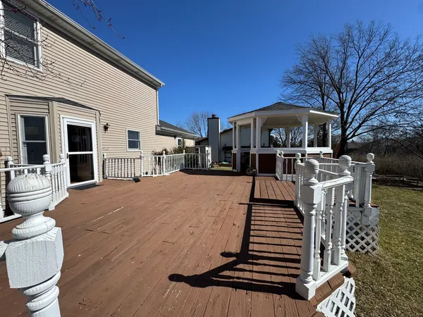 a view of a patio with couches fire pit and wooden floor