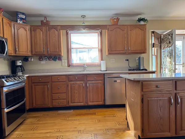 a kitchen with kitchen island granite countertop a sink cabinets and stainless steel appliances