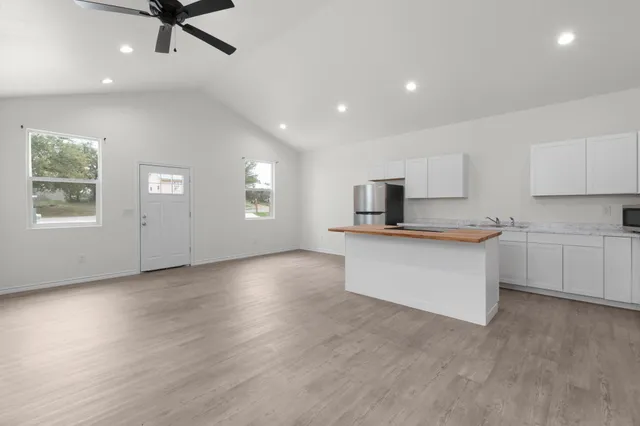 a view of kitchen with granite countertop cabinets and window